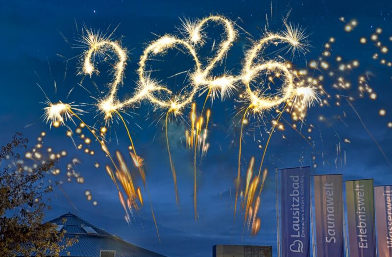 Die Außenansicht des beleuchteten Lausitzbades am Abend mit dem leuchtenden Schriftzug 2026 darüber